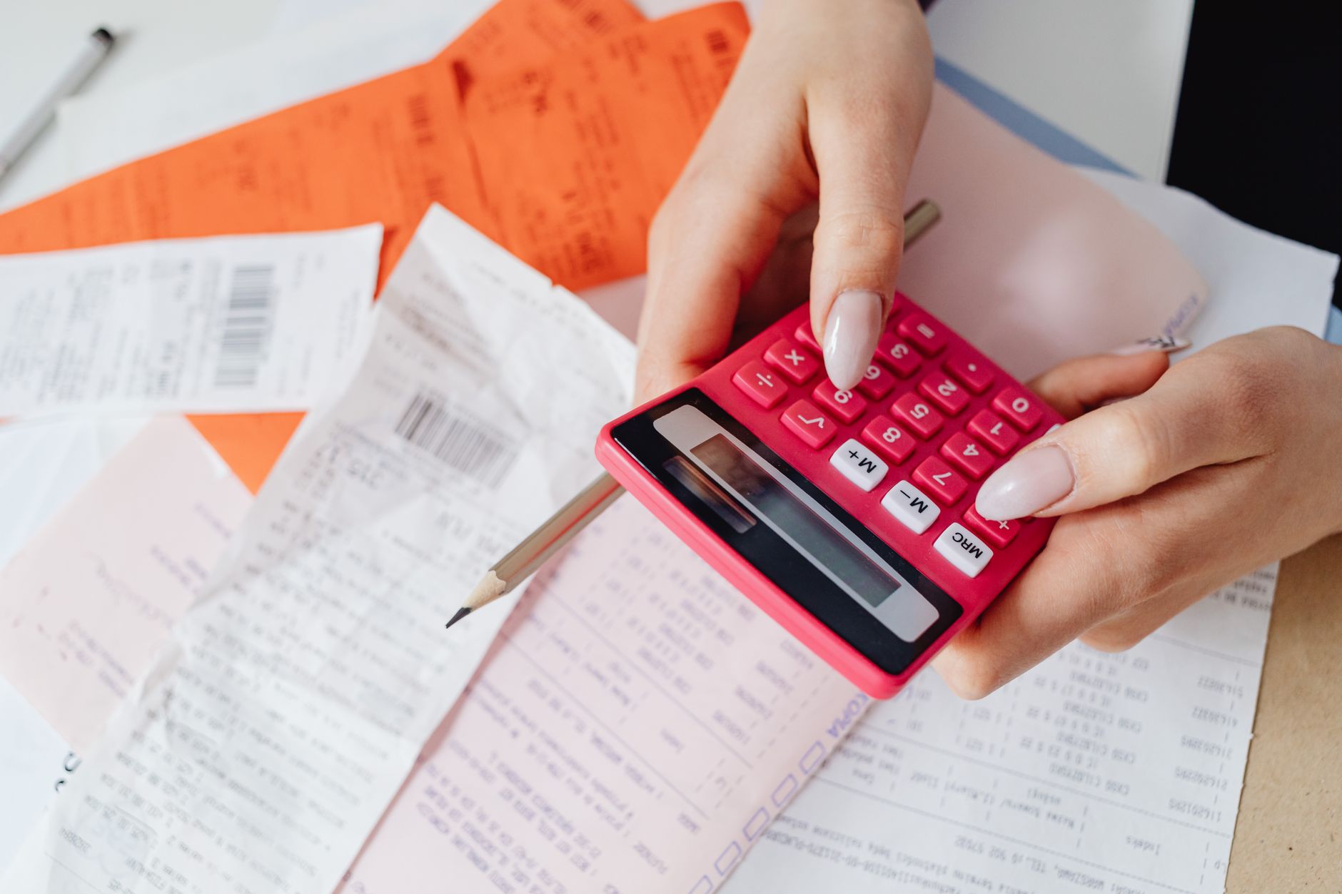 Mesa de trabalho com faturas, calculadora e anotações financeiras